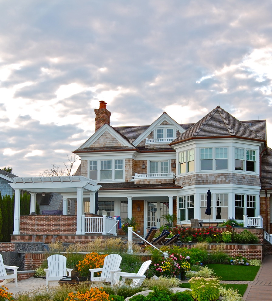 Large beach style three-story wood gable roof photo in New York
