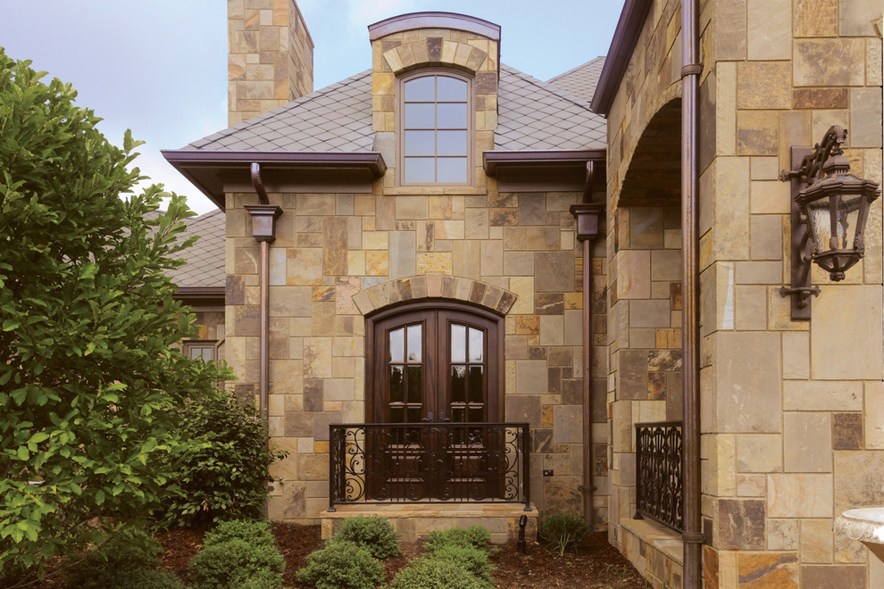 Modelo de fachada de casa marrón de estilo americano grande de dos plantas con revestimiento de piedra y tejado a cuatro aguas