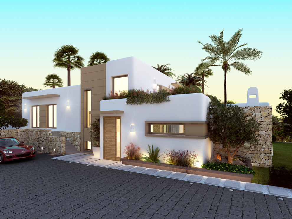Aménagement d'une grande façade de maison blanche méditerranéenne en stuc à niveaux décalés avec un toit plat.