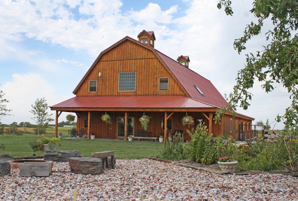 This is an example of a farmhouse house exterior in Other with wood cladding.