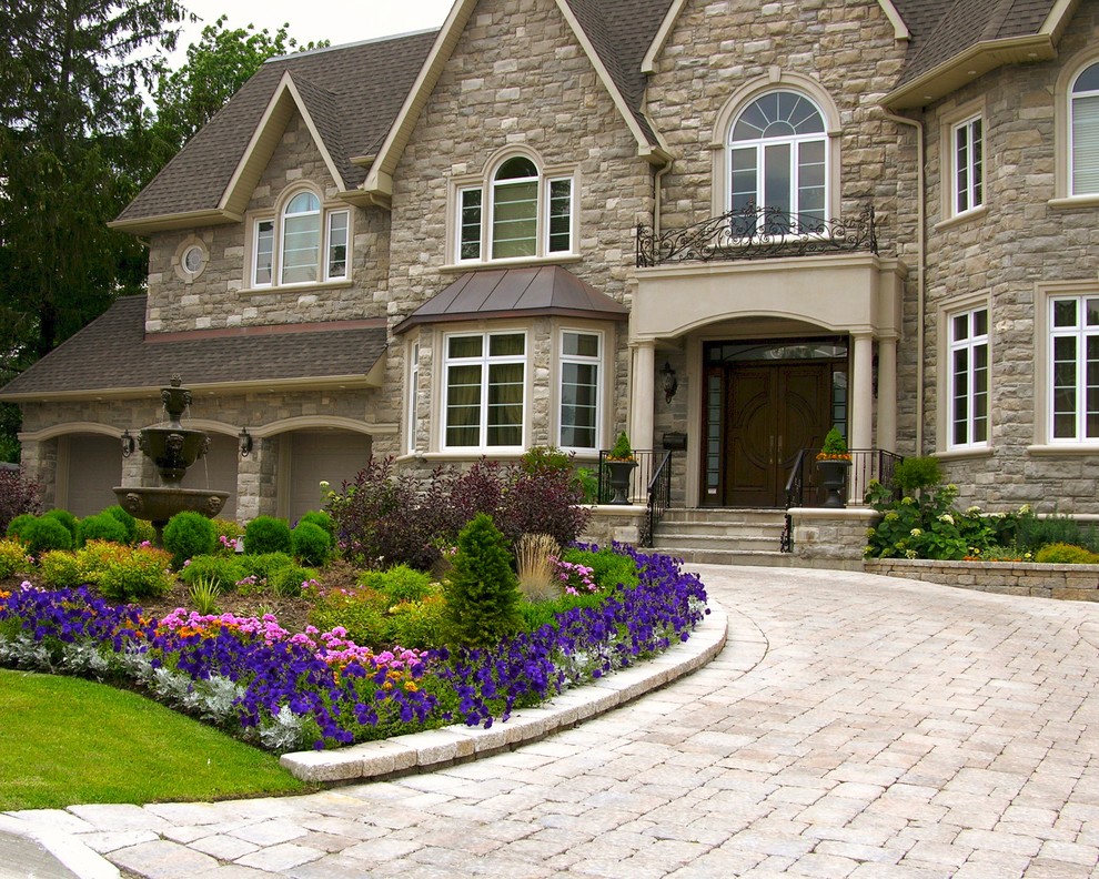 Example of a large classic two-story stone house exterior design in Toronto with a hip roof and a shingle roof