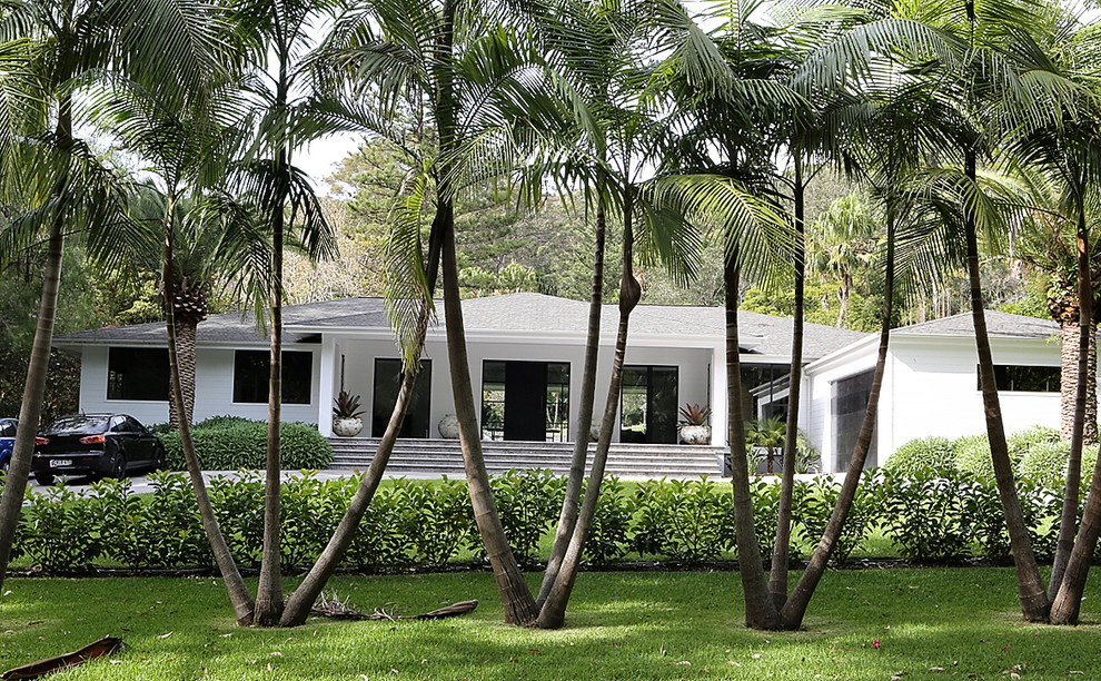 На фото: большой, одноэтажный, белый дом в современном стиле с вальмовой крышей с