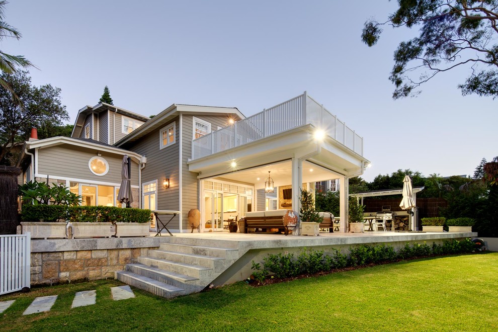 Photo of an expansive traditional house exterior in Sydney with three floors, wood cladding and a half-hip roof.
