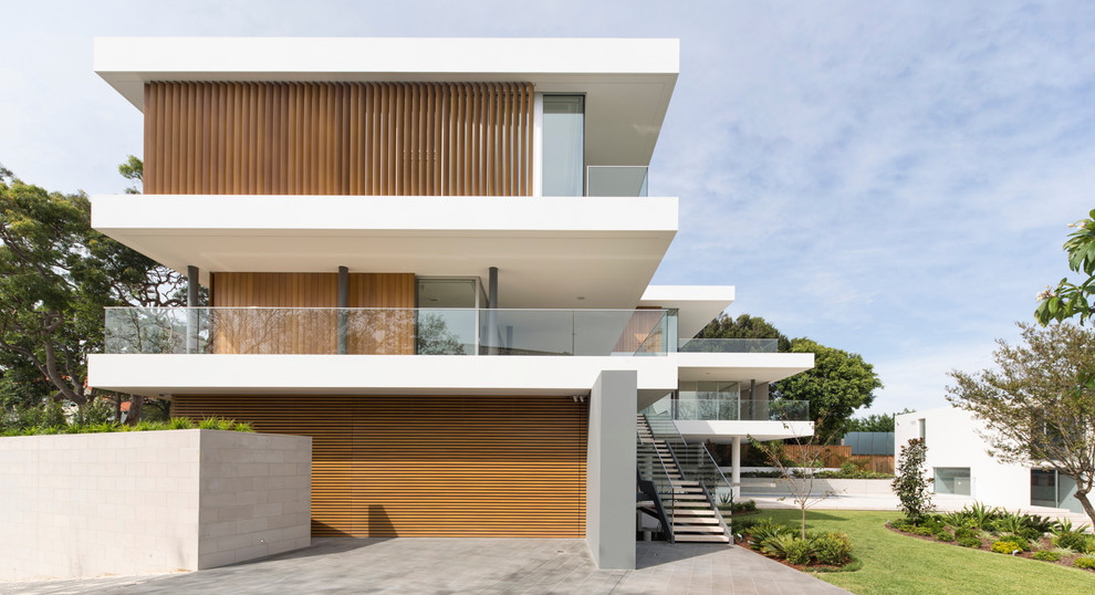 Inspiration for a large and white modern house exterior in Sydney with three floors and a flat roof.