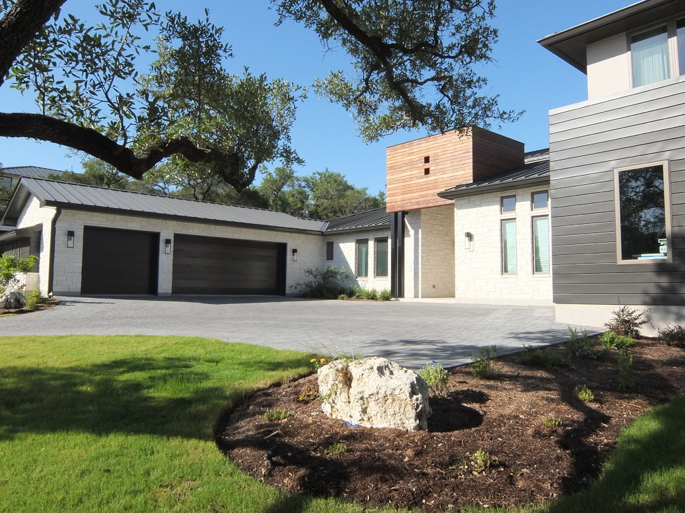 Photo of a large and gey classic two floor house exterior in Austin with metal cladding.