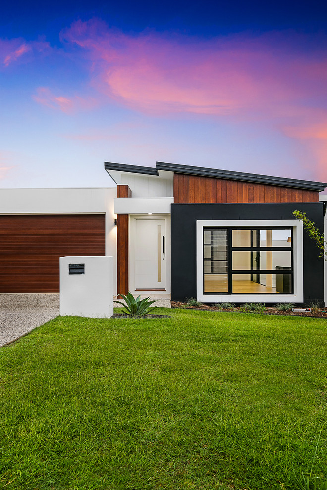 Example of a trendy one-story brick exterior home design in Brisbane with a metal roof