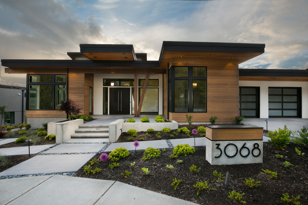 Exemple d'une grande façade de maison multicolore moderne de plain-pied avec un revêtement mixte et un toit plat.