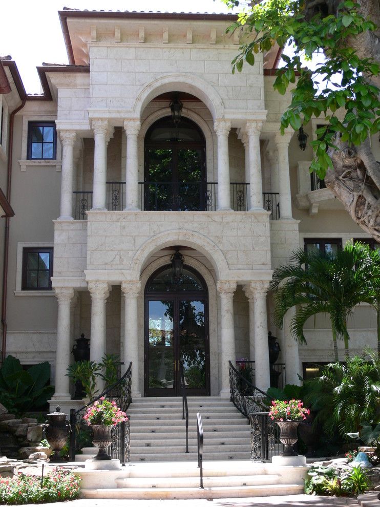 Inspiration for an expansive mediterranean house exterior in Miami with three floors and stone cladding.