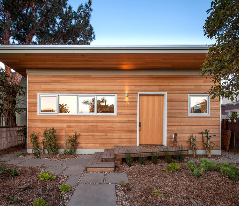 Cette image montre une façade de maison marron marine en bois de taille moyenne et à un étage avec un toit en appentis.