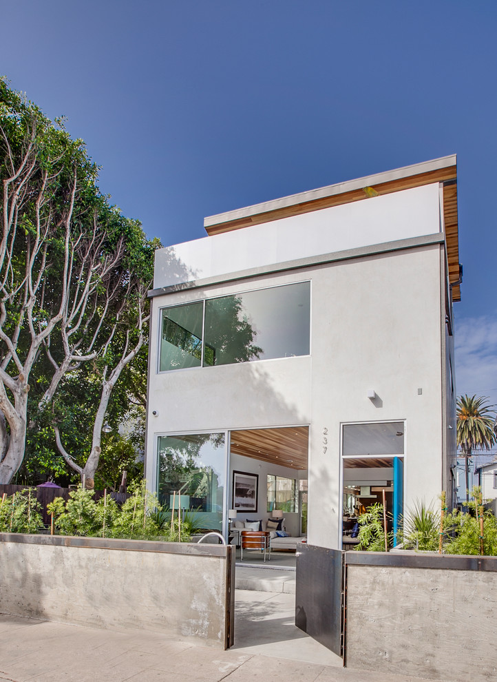 Exemple d'une façade de maison blanche tendance à un étage avec un toit plat.