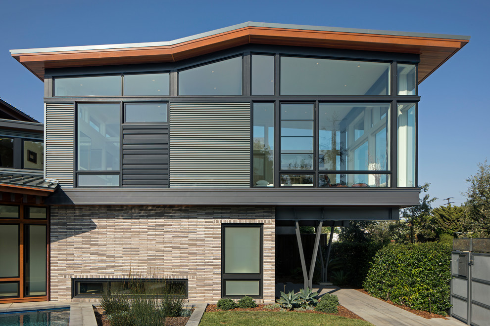 This is an example of a large contemporary two floor detached house in Los Angeles with metal cladding, a lean-to roof and a metal roof.