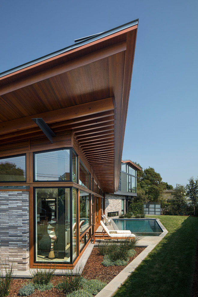Стильный дизайн: большой, двухэтажный частный загородный дом в современном стиле с облицовкой из металла, односкатной крышей и металлической крышей - последний тренд
