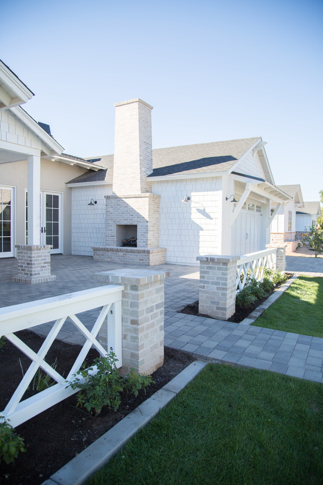 Diseño de fachada blanca de estilo de casa de campo de tamaño medio de una planta con revestimiento de aglomerado de cemento y tejado a dos aguas