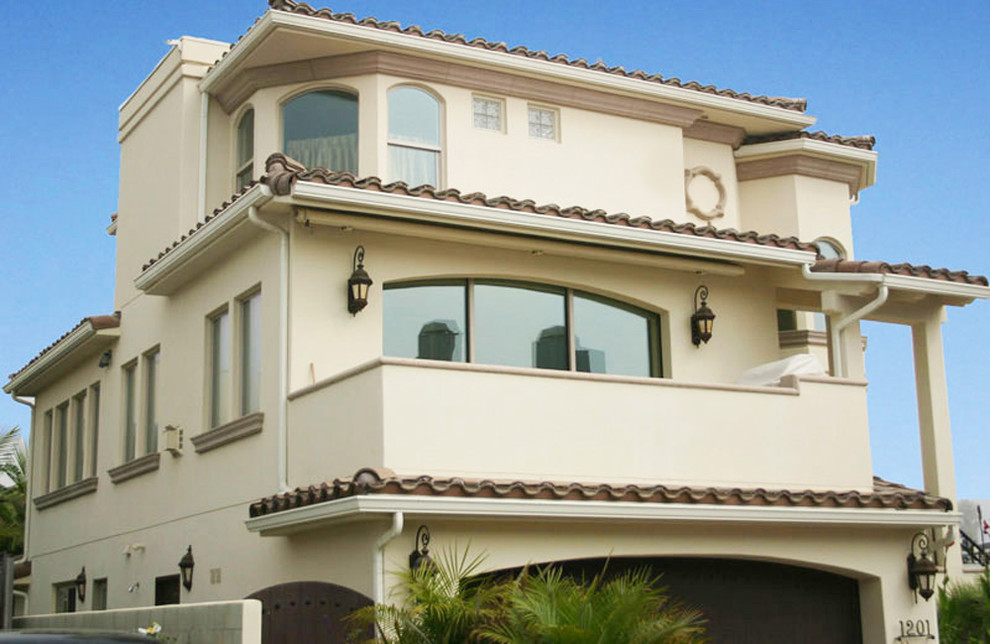 Photo of a medium sized and beige mediterranean render house exterior in Santa Barbara with three floors and a pitched roof.