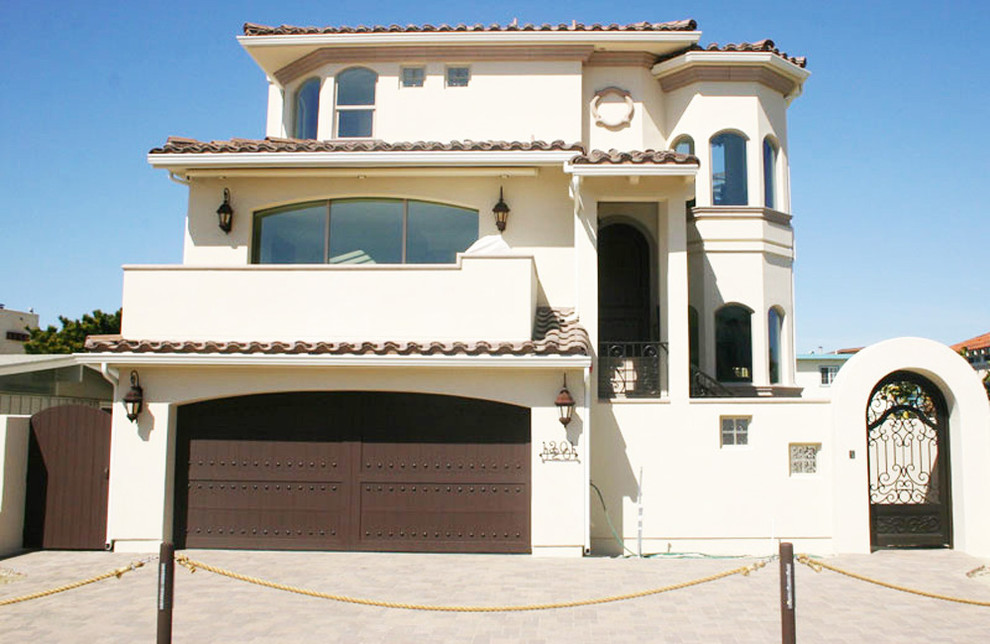 This is an example of a medium sized and beige mediterranean render house exterior in Santa Barbara with three floors and a pitched roof.