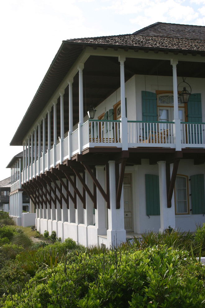 Foto på ett stort tropiskt vitt hus, med två våningar och stuckatur