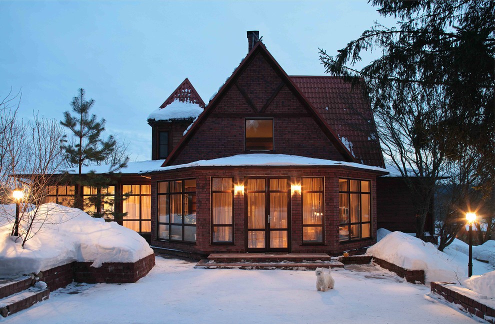 Esempio della facciata di una casa marrone country con rivestimento in mattoni e tetto a capanna