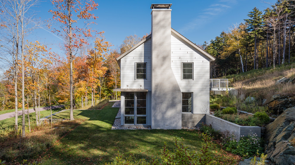 На фото: двухэтажный, белый частный загородный дом среднего размера в стиле кантри с комбинированной облицовкой, двускатной крышей и металлической крышей с