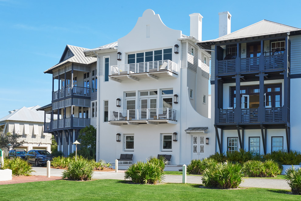Foto de fachada de casa blanca costera grande de tres plantas con revestimiento de estuco