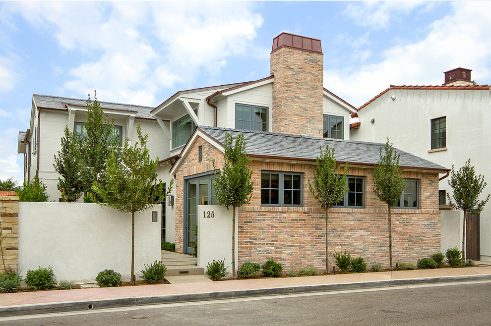 Mittelgroßes, Zweistöckiges Klassisches Einfamilienhaus mit Mix-Fassade, weißer Fassadenfarbe, Satteldach und Schindeldach in Orange County