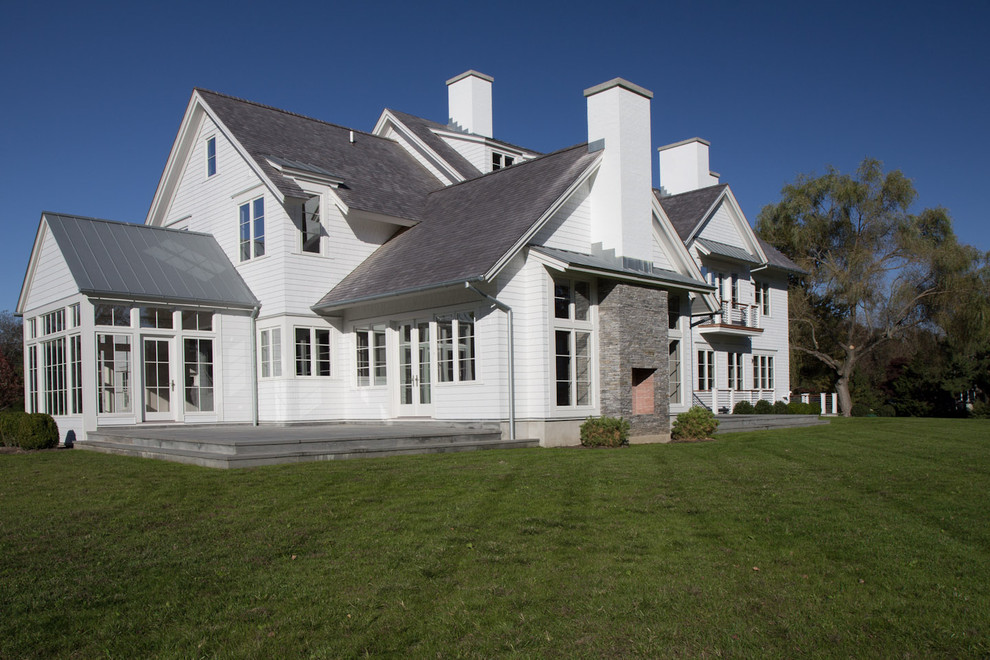 Großes, Zweistöckiges Landhausstil Haus mit Vinylfassade, weißer Fassadenfarbe und Satteldach in New York