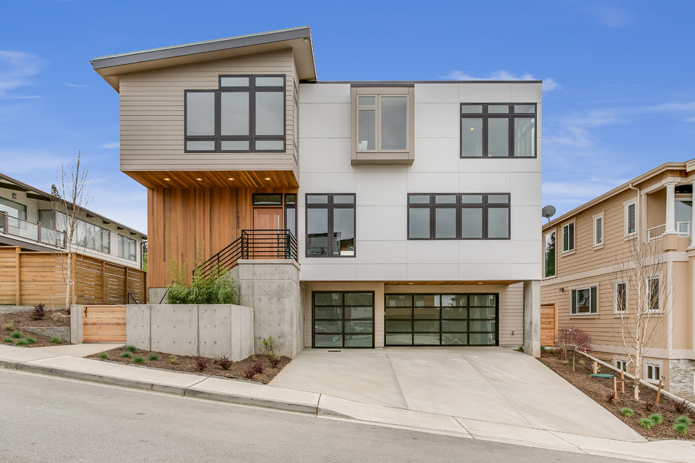 Large contemporary multicolored three-story mixed siding exterior home idea in Seattle with a mixed material roof