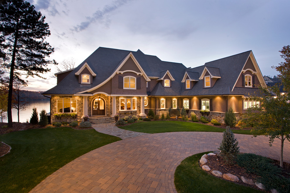 Cette image montre une grande façade de maison marron victorienne en pierre à un étage avec un toit à deux pans et un toit en shingle.
