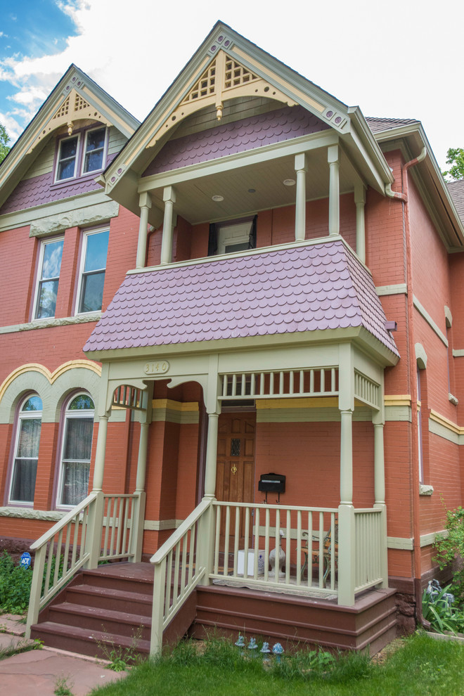 Пример оригинального дизайна: двухэтажный, красный дом среднего размера в викторианском стиле с комбинированной облицовкой и двускатной крышей
