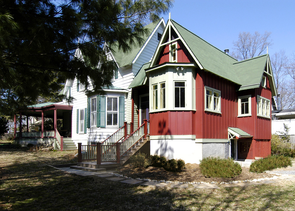 На фото: двухэтажный, красный дом среднего размера в стиле кантри с облицовкой из самана