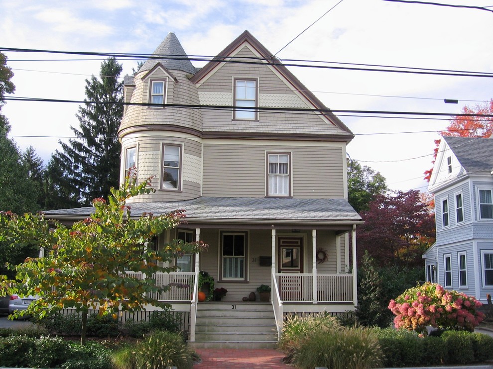 Immagine della facciata di una casa grande marrone vittoriana a tre piani con rivestimento in legno