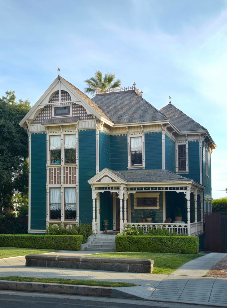 ロサンゼルスにある中くらいなヴィクトリアン調のおしゃれな二階建ての家 (緑の外壁) の写真