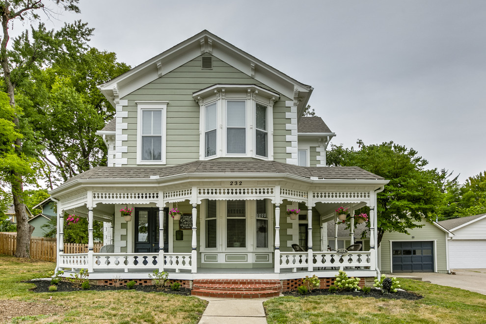 This is an example of a green victorian two floor detached house in Kansas City with a pitched roof and a shingle roof.