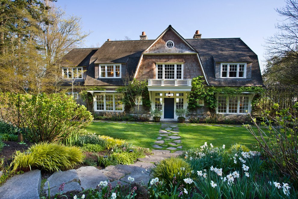 Example of an ornate two-story wood exterior home design in Seattle with a gambrel roof and a shingle roof