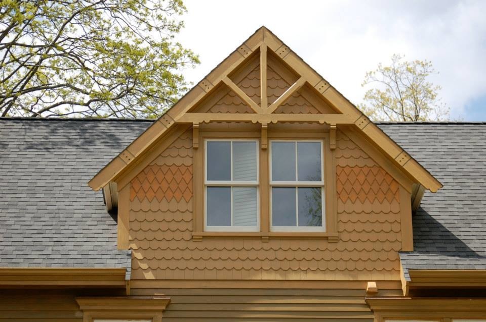 Diseño de fachada de casa amarilla tradicional grande de tres plantas con revestimiento de madera, tejado a dos aguas y tejado de teja de madera