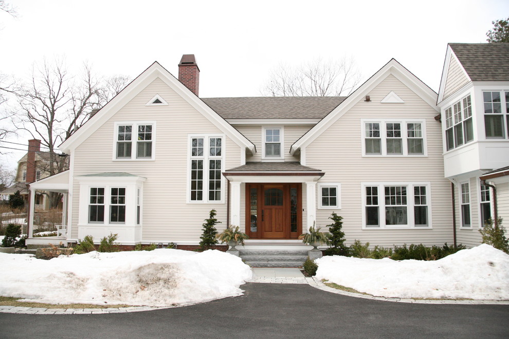 На фото: двухэтажный, белый дом среднего размера в классическом стиле с облицовкой из винила и двускатной крышей
