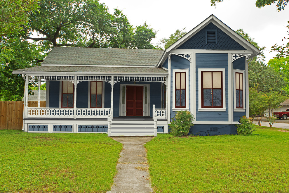 Small and blue victorian bungalow house exterior in Atlanta with wood cladding.