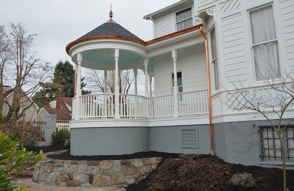 Foto de fachada blanca clásica de tamaño medio de dos plantas con revestimiento de madera y tejado a dos aguas