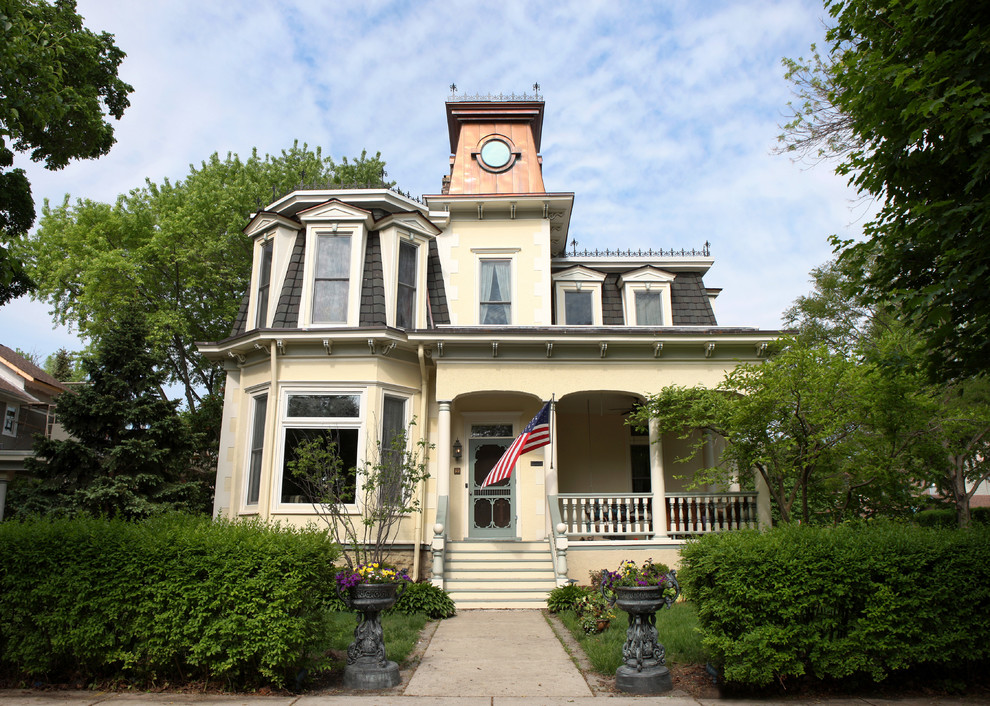 Großes, Zweistöckiges Klassisches Haus mit Putzfassade, gelber Fassadenfarbe und Walmdach in Chicago