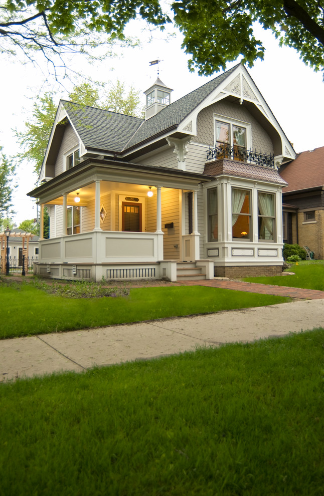 Foto de fachada de casa gris clásica de tamaño medio de dos plantas con revestimiento de vinilo y tejado de teja de madera