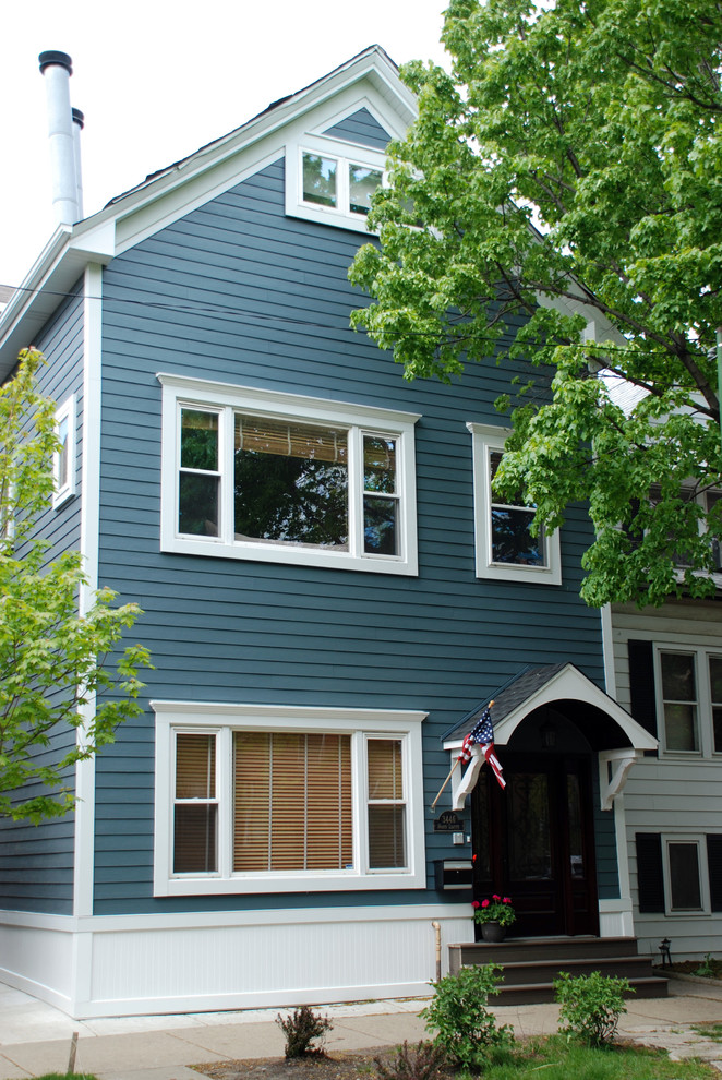 Cette image montre une façade de maison bleue victorienne en panneau de béton fibré de taille moyenne et à deux étages et plus avec un toit à deux pans et un toit en shingle.