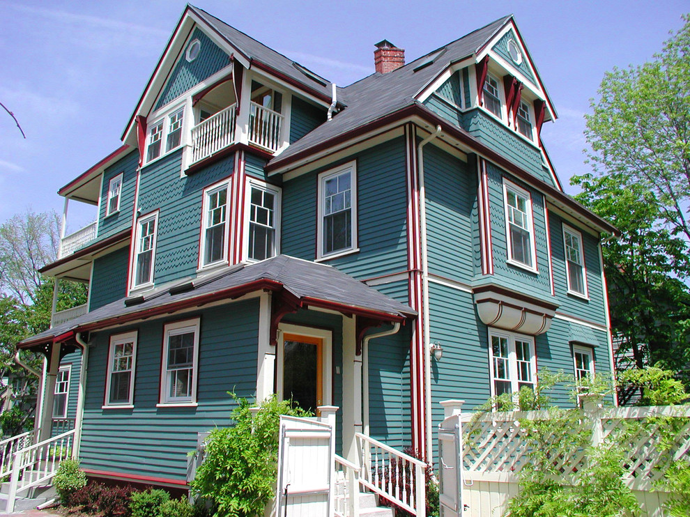 На фото: большой, трехэтажный, деревянный, синий дом в викторианском стиле с вальмовой крышей с
