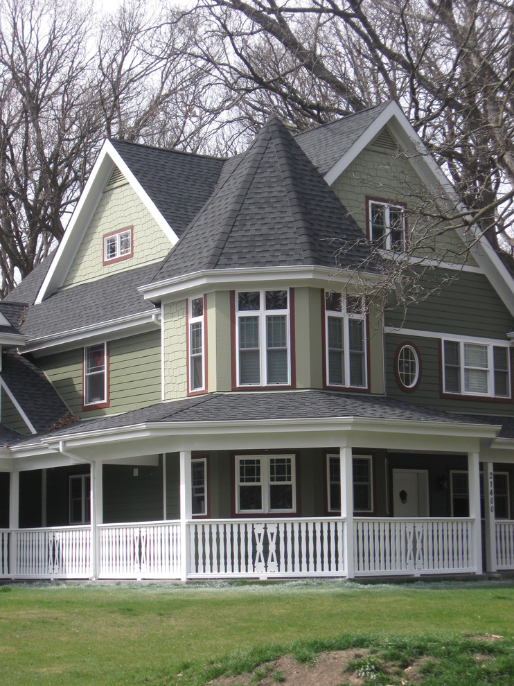 На фото: трехэтажный, зеленый дом в викторианском стиле с облицовкой из ЦСП и двускатной крышей