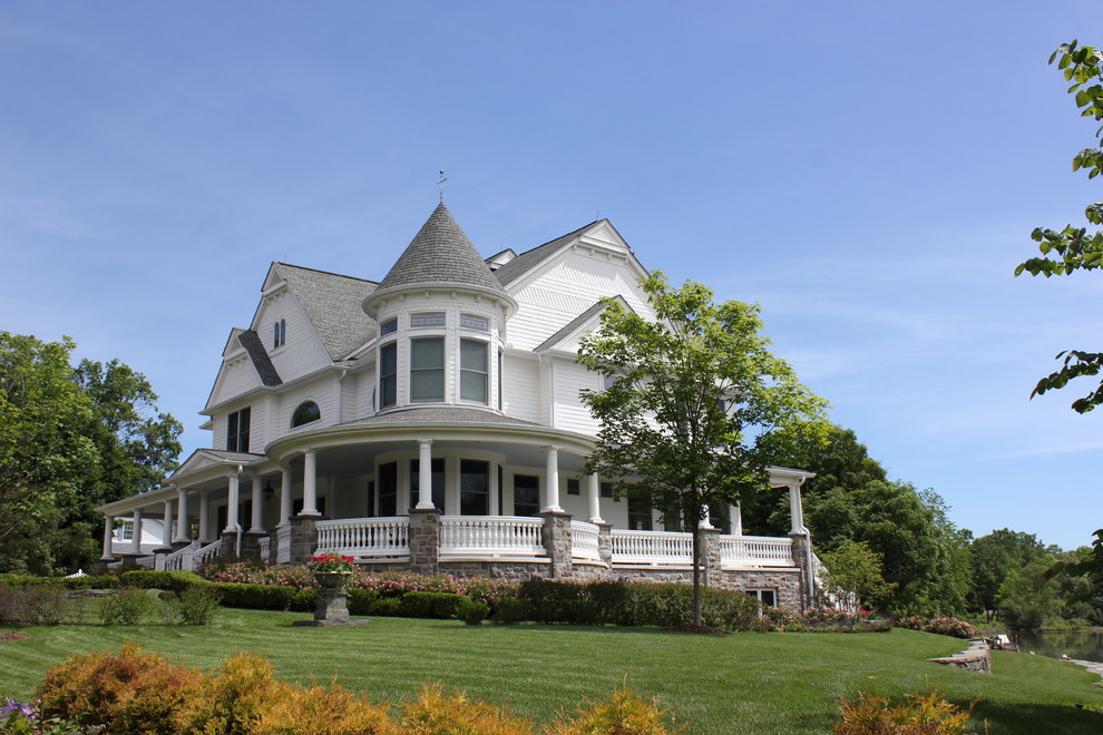 Inspiration for a huge victorian white three-story stone gable roof remodel in Detroit
