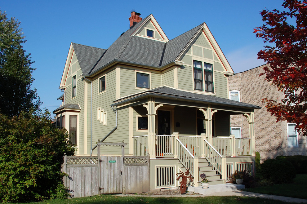 Photo of a medium sized and green victorian house exterior in Chicago with three floors, concrete fibreboard cladding and a pitched roof.