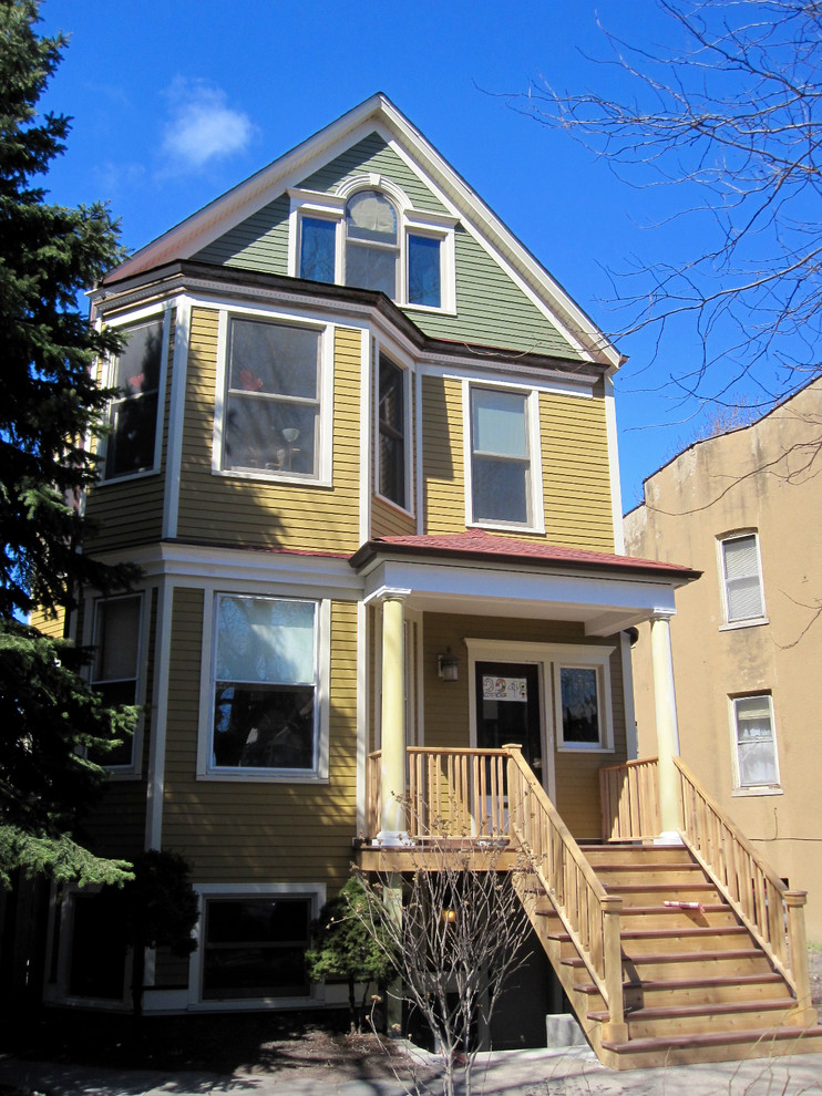 Mittelgroßes, Dreistöckiges Klassisches Einfamilienhaus mit Faserzement-Fassade, Satteldach, Schindeldach und gelber Fassadenfarbe in Chicago