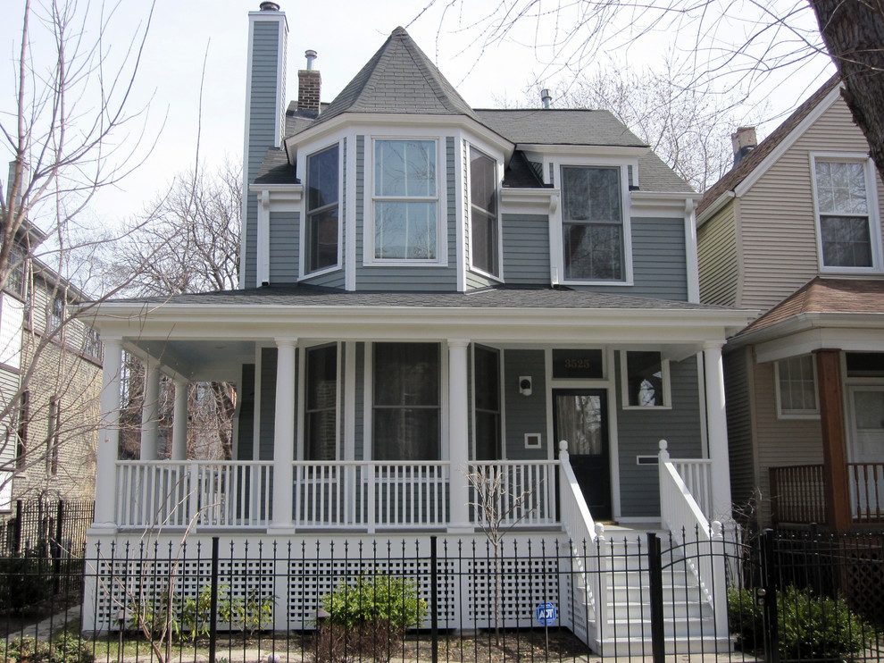 Example of a mid-sized ornate gray two-story concrete fiberboard exterior home design in Chicago with a shingle roof