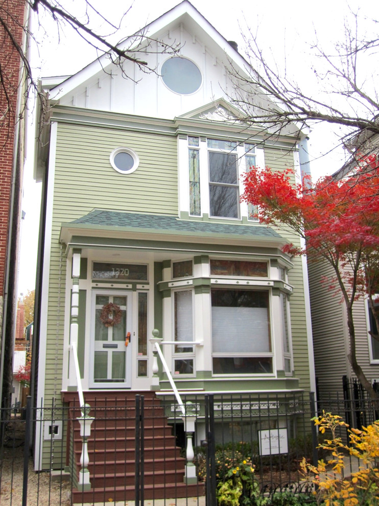Example of a mid-sized ornate green three-story concrete fiberboard house exterior design in Chicago with a shingle roof