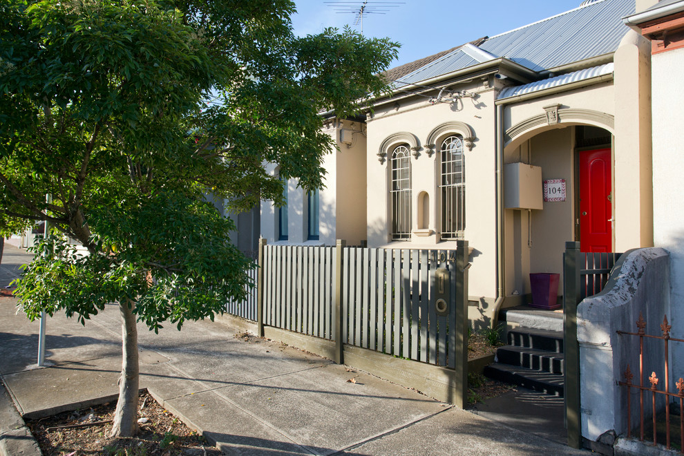 Small trendy beige one-story house exterior photo in Sydney with a hip roof and a metal roof