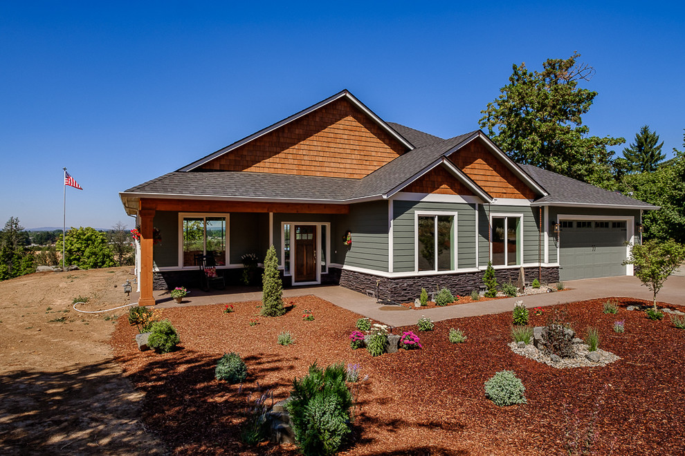 Exemple d'une façade de maison verte montagne de plain-pied avec un revêtement en vinyle et un toit en shingle.