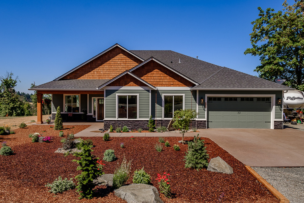 Cette photo montre une façade de maison verte montagne de plain-pied avec un revêtement en vinyle et un toit en shingle.